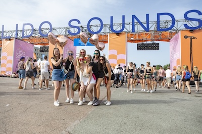 Eine Gruppe Besucherinnen vor dem Lido Sounds Infield-Eingang