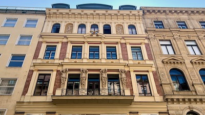 Fassade eines mehrstöckigen Warenhauses des 19. Jahrhunderts, in Créme- und Brauntönen, reich gegliedert, mit Statuen und Stuck.