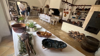 Eine große, alte Küche mit Herd, Esstisch und Küchengerät.