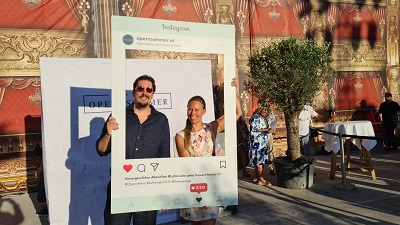 Paar hält Instagram Fotorahmen beim Besuch der Wiener Opernsommer Premiere
