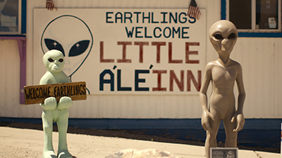Alien-Puppen vor einem Schild beim Militärgelände Area 51