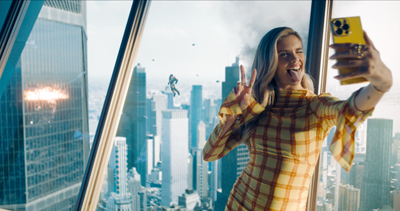 Die Freundin von Lex Luthor macht ein Selfie vor einem explodierenden Hochhaus