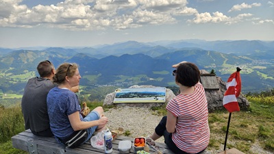 Pärchen und Frau Jausnen vor dem Panoramablick von der Gemeindealpe