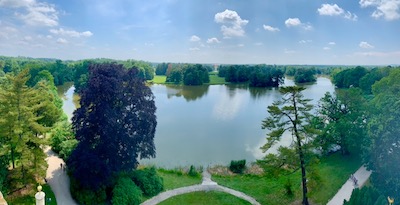 Blick auf eine flache Parklandschaft mit Teich.