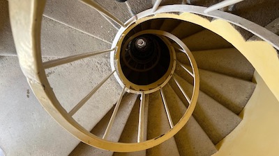 Eine schmale Wendeltreppe von oben gesehen.