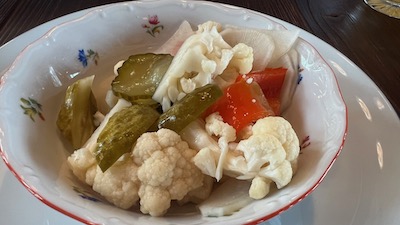 Eingelegtes saures Gemüse. Zu sehen sind Blumenkohl, Gurken, Paprika.