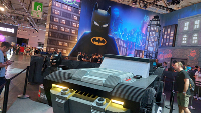 Ein Batmobil aus LEGO in Lebensgröße auf der Gamescom vor einer großen Wand mit einem Aufdruck von LEGO-Batman