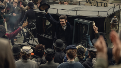Ein Mann steigt in der Serie House of Guinness aus einer Kutsche aus und winkt der jubelnden Menge.