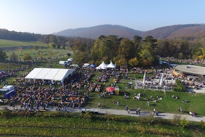 Hunderte Menschen sitzen im Freien Am Himmel in Wien beim Kürbisbauernmarkt.