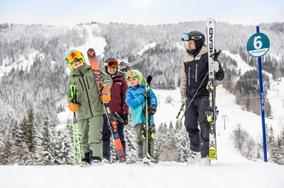 Familie in Skimontur mit Ski auf der blauen Piste Nummer 6 (Taferl ist zu sehen) in Annaberg.