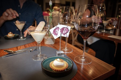 Tisch mit Rot und Weißweinglas und einem Dessert im Handwerk Restaurant in Wien