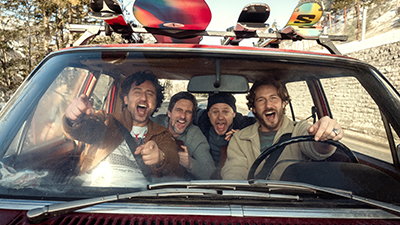 Tom Beck, Serkan Kaya, Moritz Führmann und David Rott sitzen zusammen in einer Szene der Netflix Serie Alphamännchen im Auto und haben Skiausrüstung am Gepäcksträger