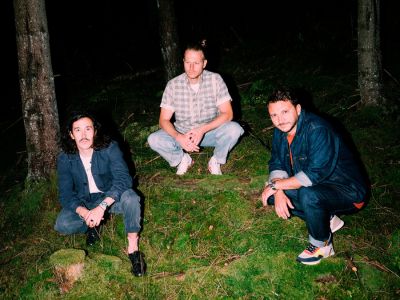 Die Band Folkshilfe hockt im Wald.