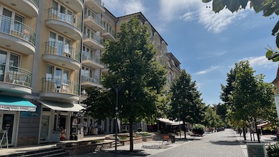 Appartementhäuser und Hotels in einem ungarischen Kurort an der Hévízer Rákóczi Straße mit Alleebäumen.