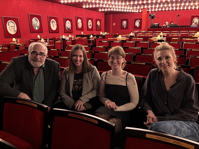 Michael Niavarani, Stefanie Riegler, Paula König und Jenny Frankl sitzen nebeneinander im roten Saal des Kabarett SIMPL