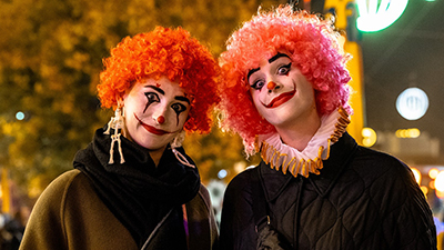 Zwei Gruselclowns mit oranger Perücke schauen in die Kamera