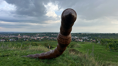 Überlebensgroße Skultpur eines Regenwurmes im Grünen, im Hintergrund Blick auf Langenlois
