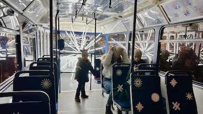Inneres einer Weihnachtsstraßenbahn in Bratislava. Weihnachtliche Beleuchtung. Sitzbespannung mit Sternen und Schneeflocken.