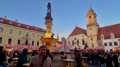 Der Hauptplatz von Bratislava mit dem Rolandsbrunnen und dem Alten Rathaus. Zur Weihnachtszeit mit dem Weihnachtsmarkt in der Abenddämmerung