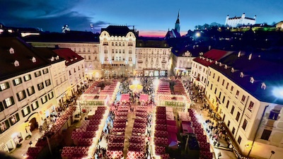 Der Hauptplatz von Bratislava mit dem Weihnachtsmarkt in nächtlicher Beleuchtung. Im Hintergrund er Martinsdom und die Burg.