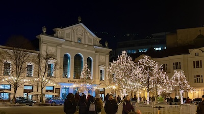 Die Alte Markthalle (Stará tržnica) von 1910 in Bratislava zur Weihnachtszeit. Nachtaufnahme mit beleuchteten Christbäumen am Vorplatz.