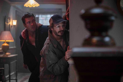 Glew Powell und Michael Cera verstecken sich vor Feinden hinter einer Hauswand