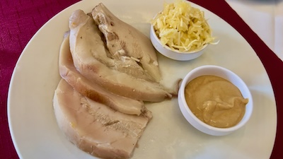 Ein Schweinsgöderl mit Estragaonsenf und Apfelkren.
