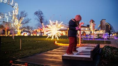 Kind spielt mit den Füßen auf überdimensionalen Klaviertasten