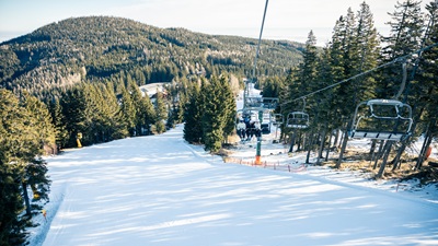 Breite rote Piste mit Sessellift. Die Sonnenbahn in Mönichkirchen.