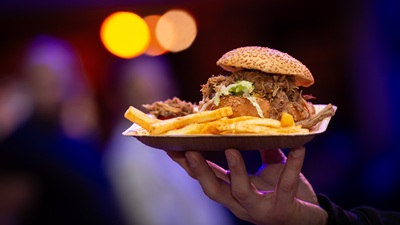 BUrger mit Pulled Pork und Fries auf einem Teller auf der Hand bei der METAbowl in Wien