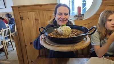 Frau mit Linsenpfanne und Knödel