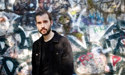 Musiker Modest Oda vor Graffiti-Wand