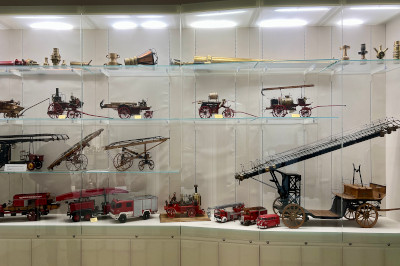 Modelle von alten Feuerwehrfahrzeugen in einer Vitrine im Feuerwehrmuseum Wien