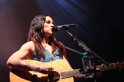 Amy MacDonald singt mit Gitarre ins Microphon bei ihrem Konzert in Wien.