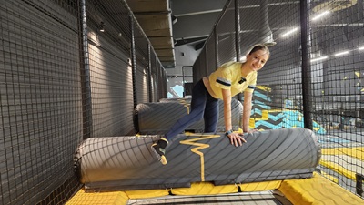 Mädchen klettert über Bounce Parcours Hürde