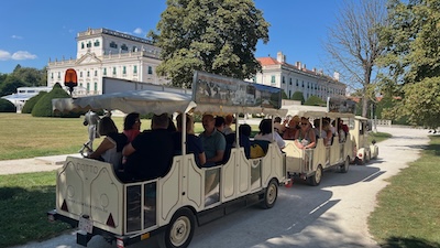 Touristenzug im Park von Schloss Esterházy in Fertöd. Im Hintergrund das Schloss.