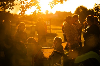 Menschen im Abendlicht in Liegestühlen und stehend beim Paradies-Sommer im Südburgenland