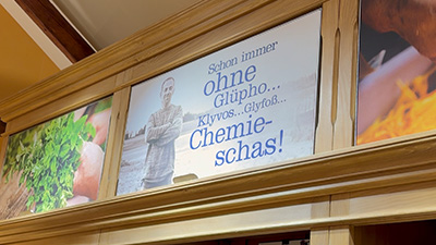 Schild mit Werbetext von Sonnentor: Schon immer ohne Glüpho... Klyvos... Glyfoß... Chemie-schas!