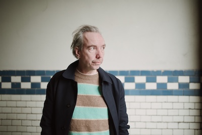 Wien-Konzerte Highlight Olli Schulz vor Wand mit Karomuster