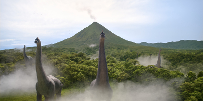 Dinosaurier auf der prähistorischen One-Piece-Insel Little Garden mit rauchendem Vulkan