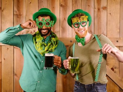 Zwei Männer mit je einem schwarzen und einem grünen Bier in der Hand und St. Patrick's Day Outfit
