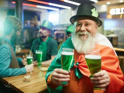 Mann mit zwei Gläsern grünem Bier.