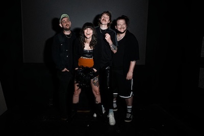 Die Band Waits vor dunklem Hintergrund