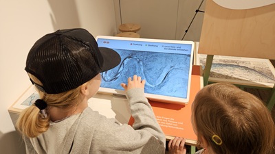Kind bedient einen Touchscreen von einem Flussströmungs Modell