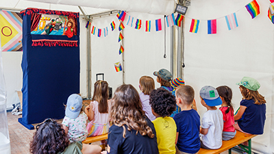 Kinder schauen einem Kasperltheater zu