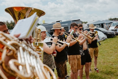 Gruppe von Gästen es Musikfestivals Woodstock der Blasmusik spielen spielen auf ihren Instrumenten
