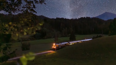 Ötscherbär Erlebniszug fährt in der Nacht, im Hintergrund Sternenhimmel