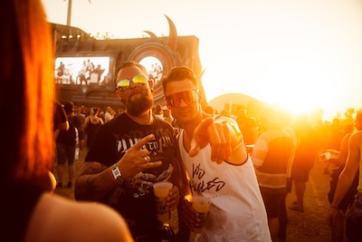 zwei Nova Rock Fans stehen or der Bhne im Sonnenuntergang