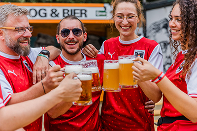 Fußball-Fans stoßen mit BIer und Radler an.