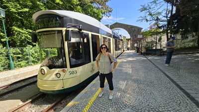 Frau vor dem neuen Wagen der Pöstlingbergbahn bei der Endstation am Pöstlingberg.